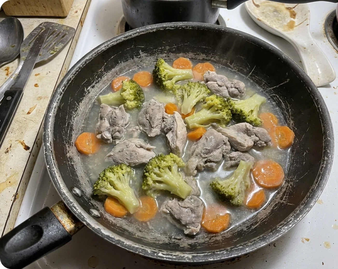 A worn, scratched non-stick coated frying pan